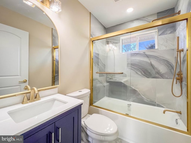 bathroom featuring toilet, bath / shower combo with glass door, and vanity