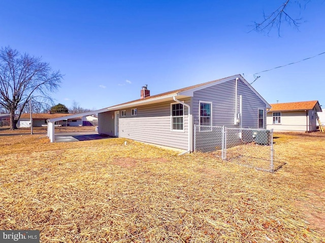 view of side of home featuring a yard, fence, and a chimney