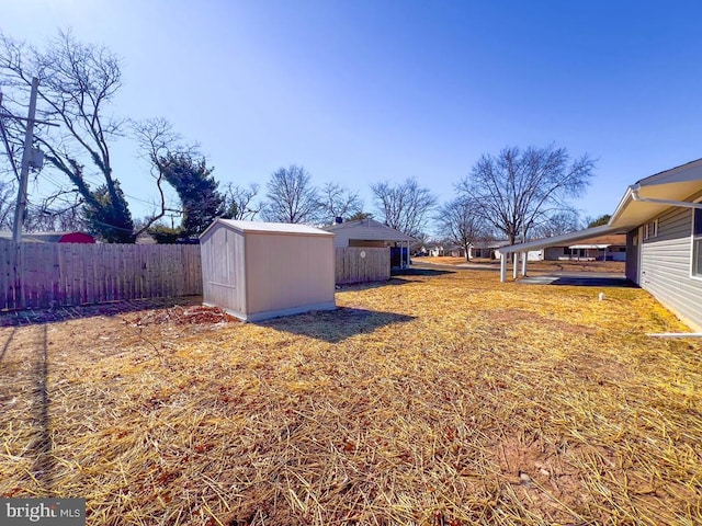 view of yard with an outbuilding, fence, and a storage unit