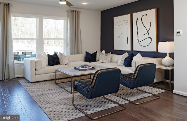 living room with a ceiling fan, baseboards, and wood finished floors