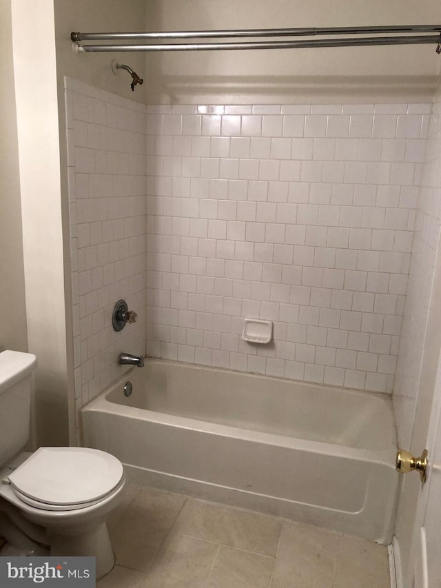 bathroom featuring toilet, shower / washtub combination, and tile patterned floors