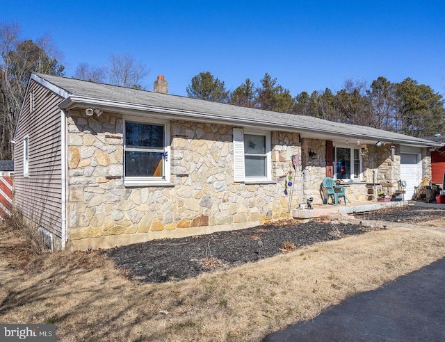 single story home featuring a garage, stone siding, and a chimney