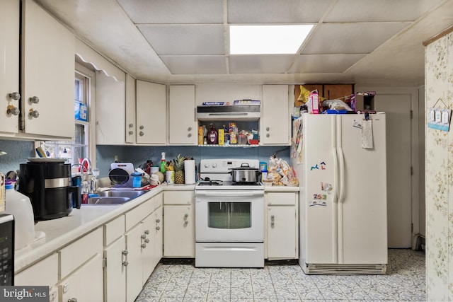 kitchen with light countertops, white appliances, a sink, and white cabinets