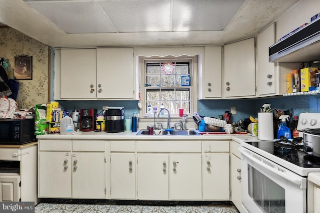 kitchen featuring black microwave, light countertops, a sink, and electric range