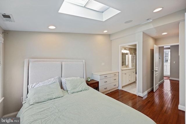 bedroom featuring light wood-style flooring, a skylight, visible vents, and baseboards