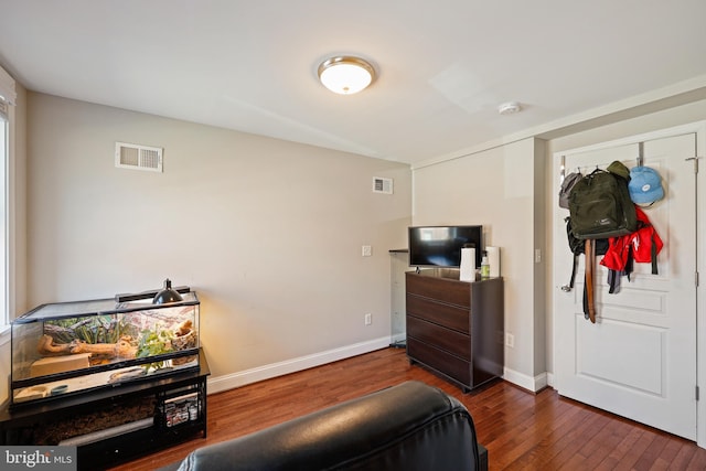 interior space with dark wood-type flooring, visible vents, and baseboards