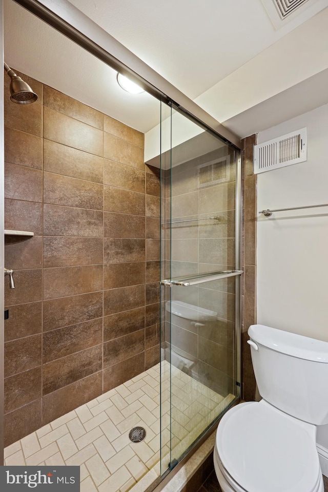 full bath featuring toilet, a stall shower, and visible vents