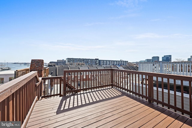 wooden terrace featuring a view of city and a water view