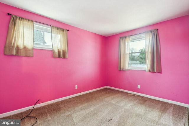 unfurnished room featuring carpet flooring, visible vents, and baseboards