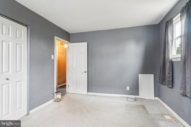 bedroom featuring light carpet, baseboards, and a closet