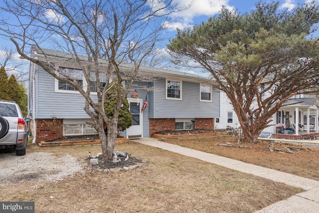 split foyer home featuring brick siding