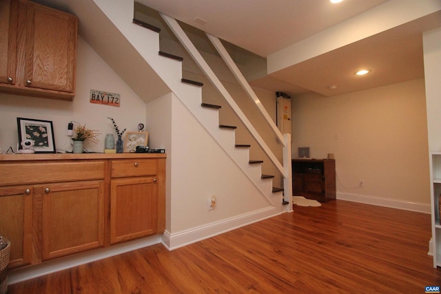 interior space with stairway, wood finished floors, and baseboards