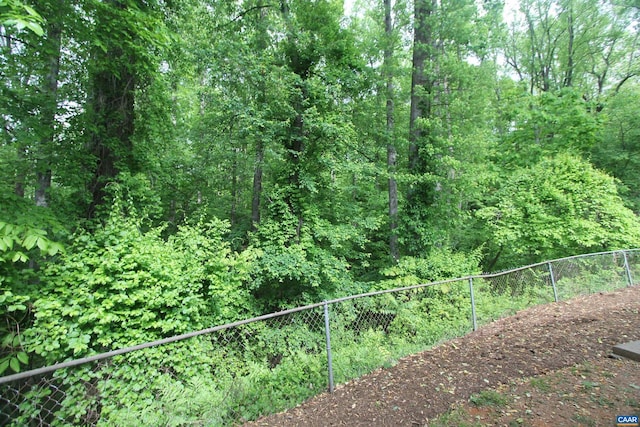 exterior space with fence and a view of trees