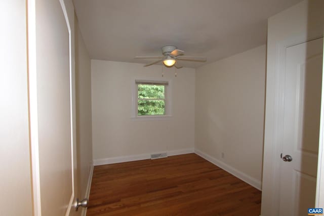 unfurnished room with ceiling fan, wood finished floors, visible vents, and baseboards