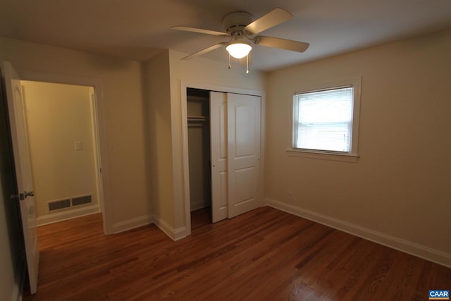 unfurnished bedroom featuring baseboards, visible vents, a ceiling fan, dark wood-type flooring, and a closet