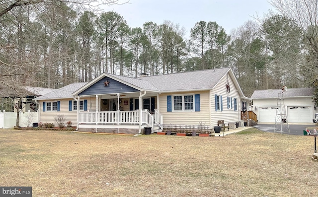 ranch-style home featuring an outbuilding, covered porch, roof with shingles, and a front lawn