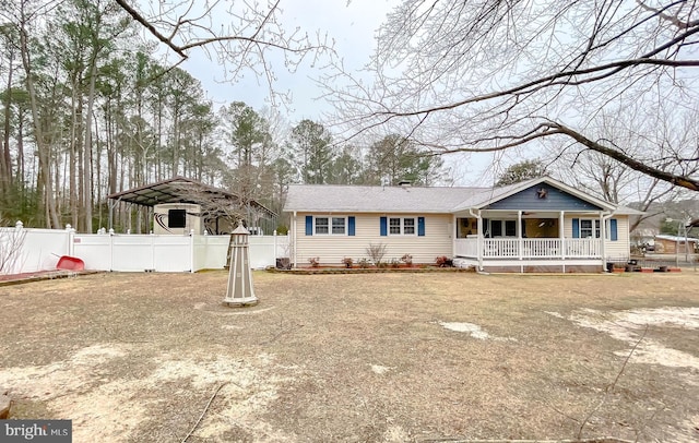 view of front of home featuring fence private yard, covered porch, and a detached carport