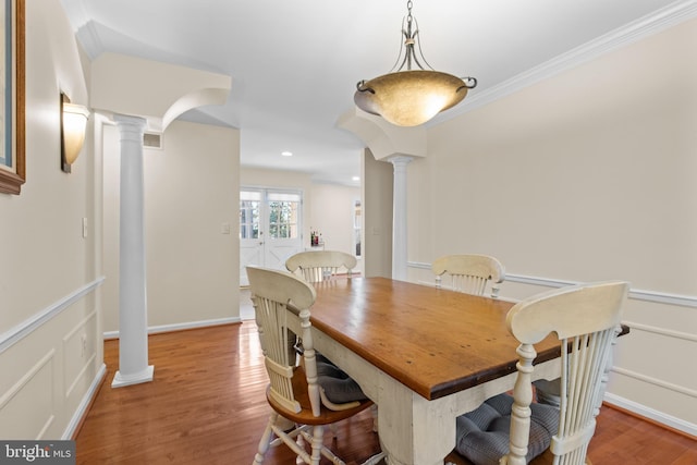 dining area with light wood-style floors, visible vents, crown molding, and ornate columns