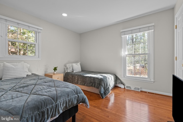 bedroom with recessed lighting, visible vents, baseboards, and hardwood / wood-style flooring