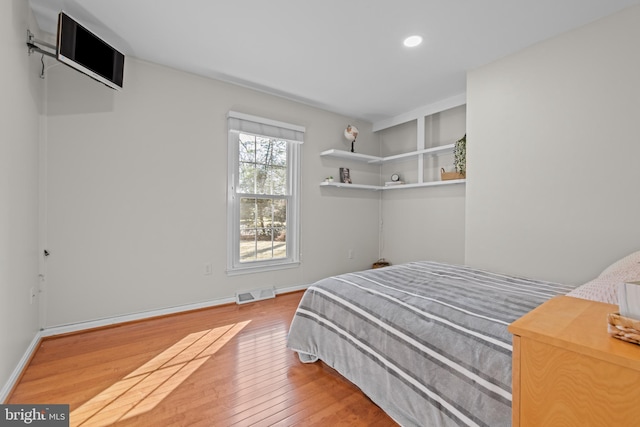 bedroom with light wood-type flooring, visible vents, baseboards, and recessed lighting