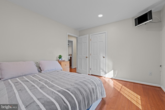 bedroom with light wood-style floors, recessed lighting, and baseboards