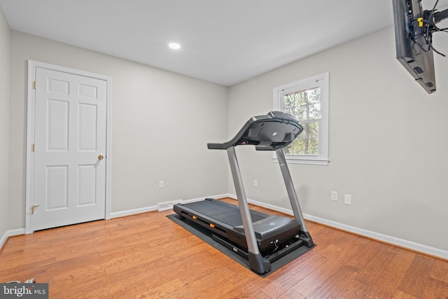 exercise room featuring visible vents, baseboards, and wood finished floors