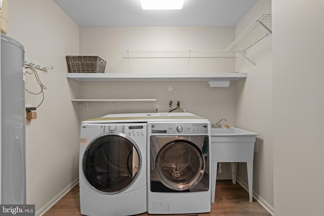 laundry room featuring dark wood-type flooring, washing machine and dryer, laundry area, and baseboards