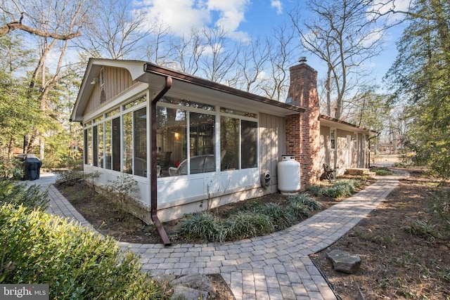 view of home's exterior featuring a sunroom and a chimney