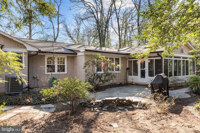 exterior space with central AC unit, a patio area, and a sunroom