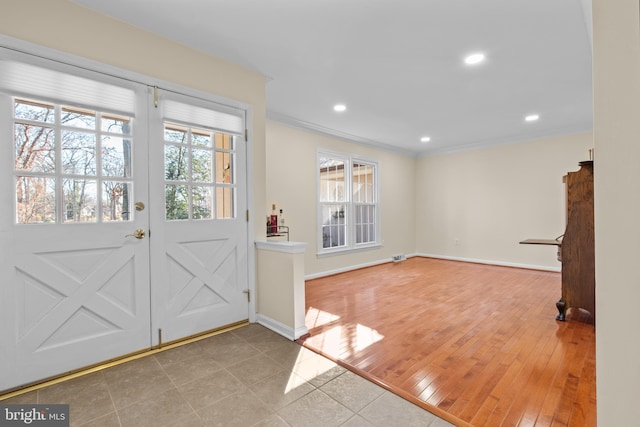 foyer entrance with ornamental molding, recessed lighting, light wood-style flooring, and baseboards