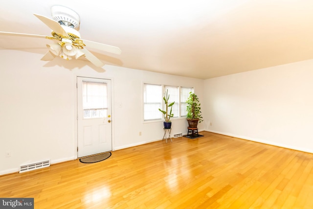 interior space with ceiling fan, wood finished floors, visible vents, and baseboards