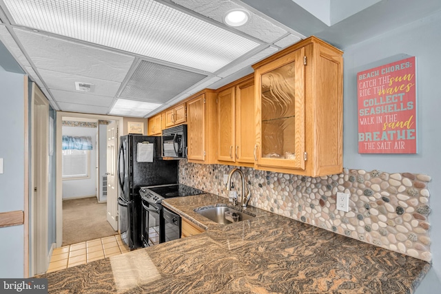 kitchen with brown cabinets, tasteful backsplash, visible vents, a sink, and black appliances