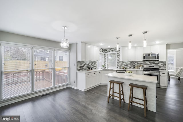 kitchen featuring stainless steel appliances, light countertops, visible vents, and a sink