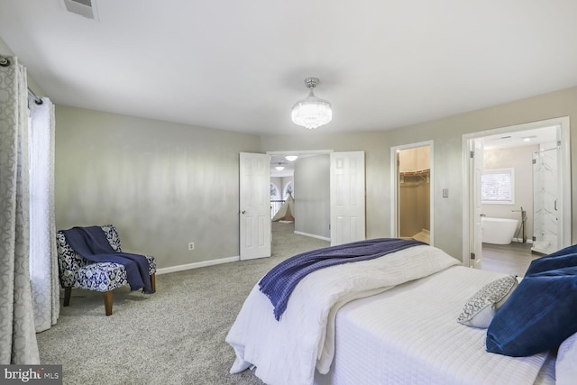 carpeted bedroom with baseboards, visible vents, ensuite bathroom, a spacious closet, and a closet