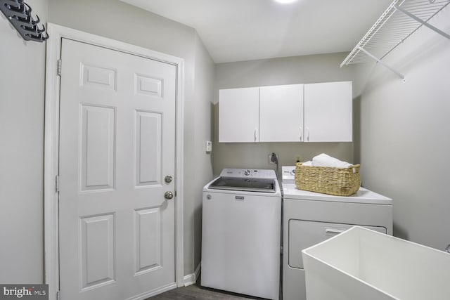 clothes washing area with cabinet space, separate washer and dryer, and a sink