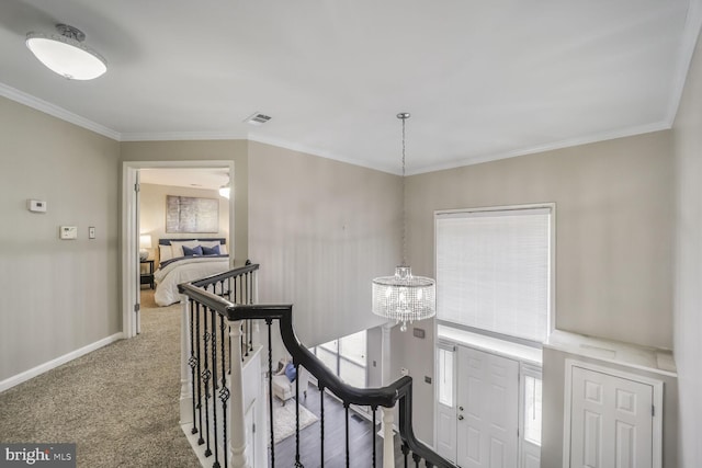 hall featuring carpet, crown molding, an upstairs landing, a chandelier, and baseboards