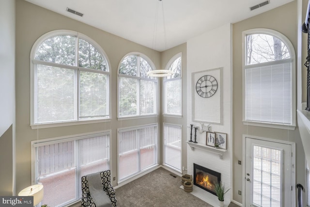 carpeted living area with a fireplace and visible vents