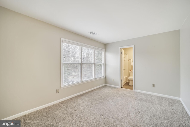 carpeted empty room featuring visible vents and baseboards