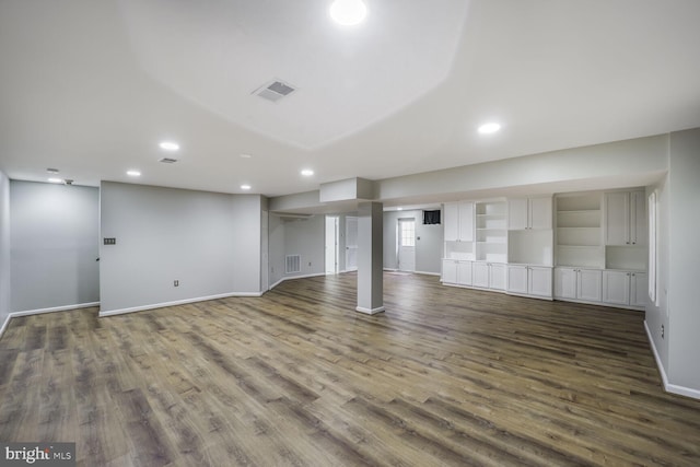 finished basement with dark wood-style floors, baseboards, visible vents, and recessed lighting