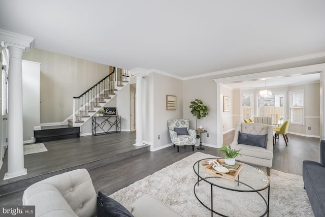 living area with ornate columns, baseboards, stairway, and wood finished floors