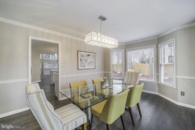 dining room featuring a healthy amount of sunlight, baseboards, ornamental molding, and wood finished floors