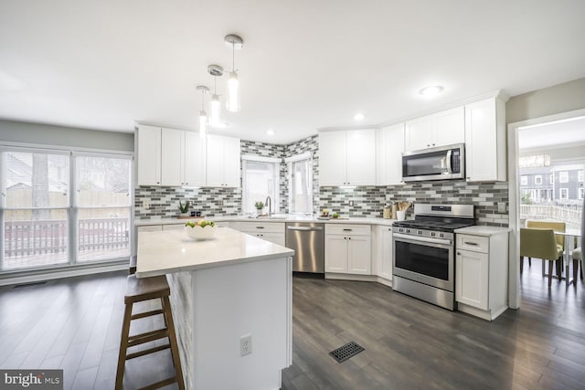 kitchen with white cabinets, plenty of natural light, stainless steel appliances, and light countertops