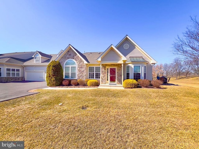 view of front of home featuring stone siding, aphalt driveway, and a front lawn