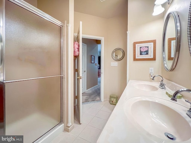 full bathroom with double vanity, a stall shower, a sink, and tile patterned floors