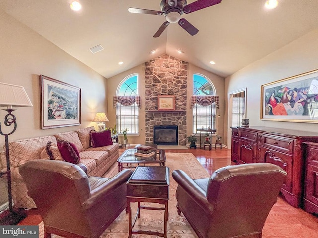 living room featuring plenty of natural light, a fireplace, visible vents, and ceiling fan