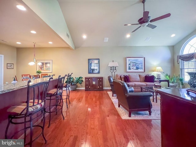 living area with visible vents, a ceiling fan, lofted ceiling, wood finished floors, and recessed lighting