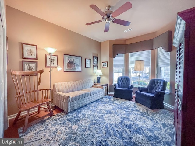 living room featuring visible vents, ceiling fan, and baseboards