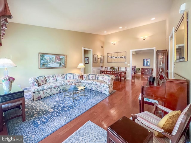 living room featuring lofted ceiling, wood finished floors, visible vents, and recessed lighting