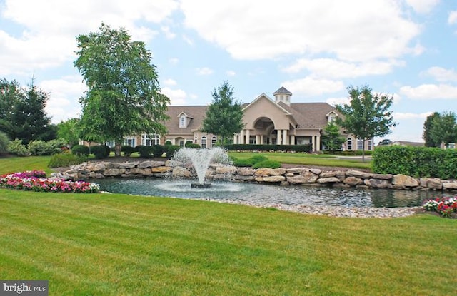 view of home's community with a yard and a water view