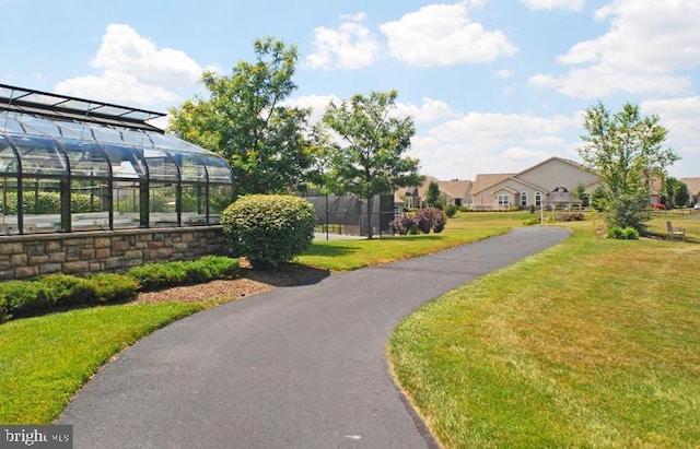 view of community featuring a yard and fence